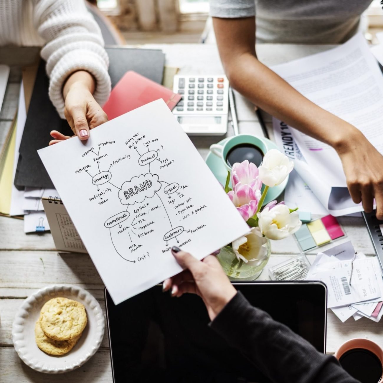 colleagues-handing-branding-plan-strategy-to-other-e1658932493848